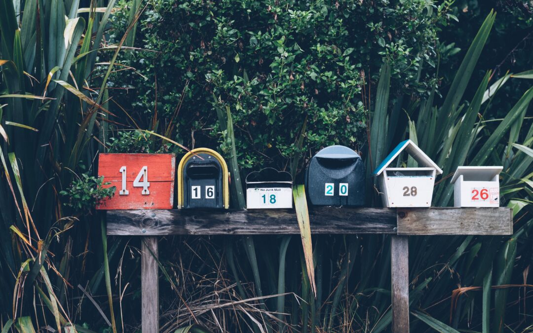 A row of five metal mailboxes sit atop a wooden support.