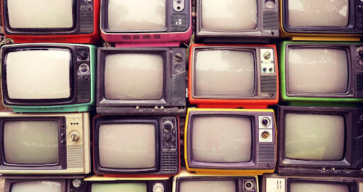 Stacks of old style tvs in rows.