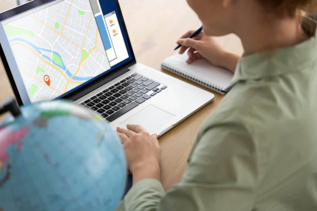 A woman uses a laptop to locate a business on a map