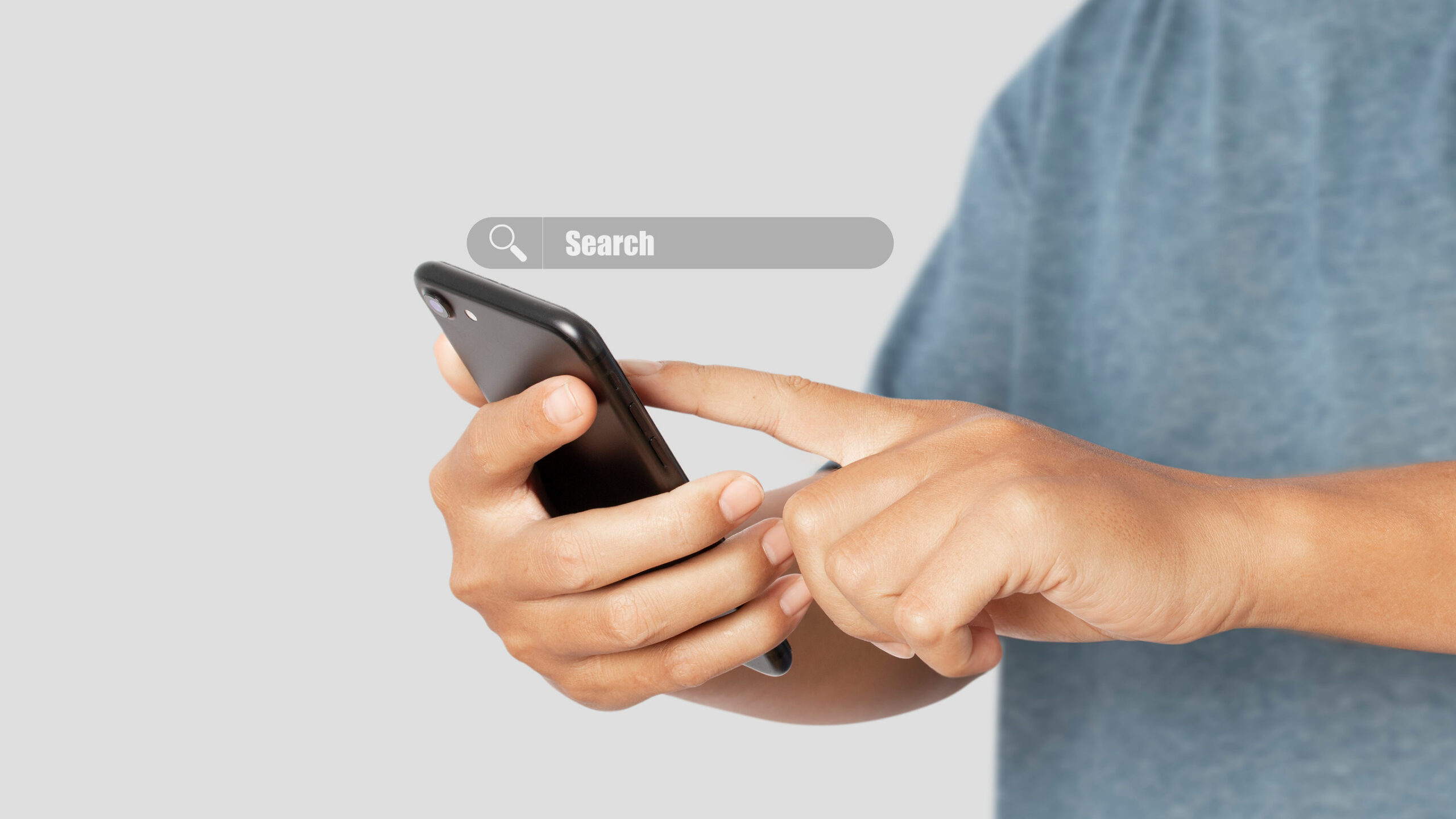 Close-up of a person using a smartphone to search online, representing how customers look for local businesses and services before making a purchasing decision.