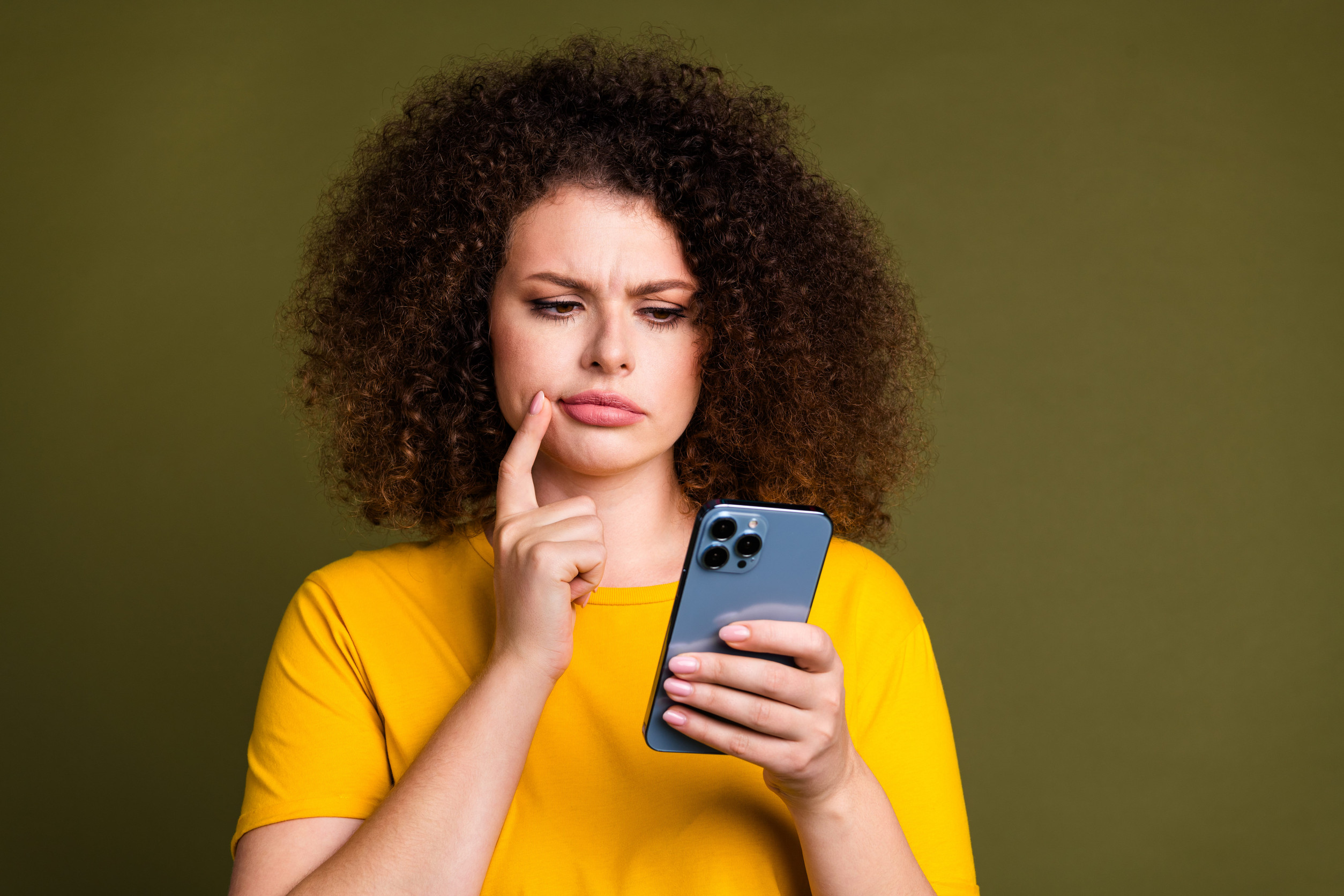 Confused woman checking her phone for inconsistent business contact information