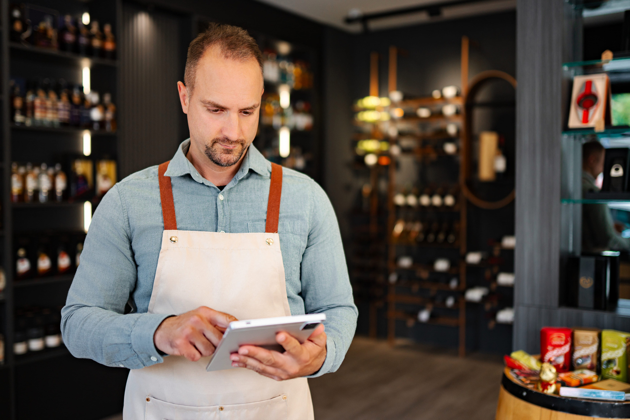 Small business owner reviewing his store's online listing details on a tablet